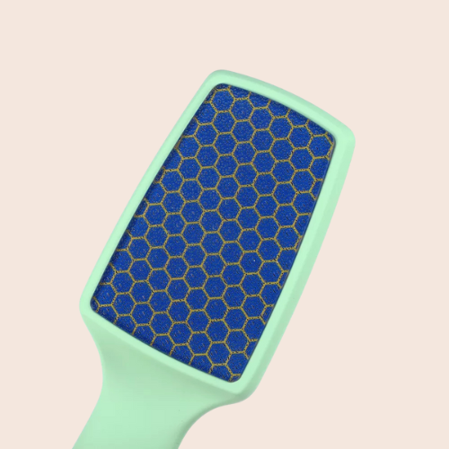 Close-up of the fine abrasive surface on a light green nano-glass foot file against a light background.