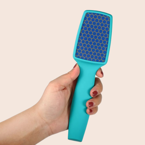 Hand holding a teal nano-glass foot file with fine abrasive surface on a light background.